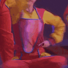 a close up of a person wearing a yellow apron and a red sweater .