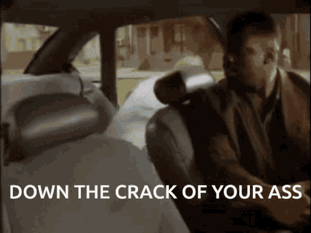 a man sitting in the back seat of a car with the words down the crack of your ass below him
