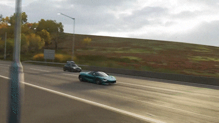 two cars are driving down a highway and one has a roof rack on top of it