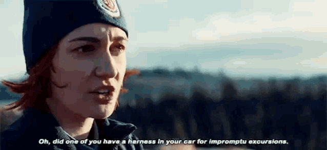 a woman wearing a beanie and a jacket is talking to another woman .