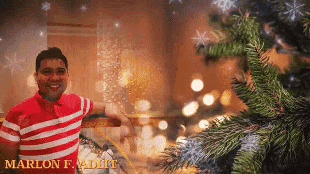 a man standing in front of a christmas tree with the name marlon f. adult