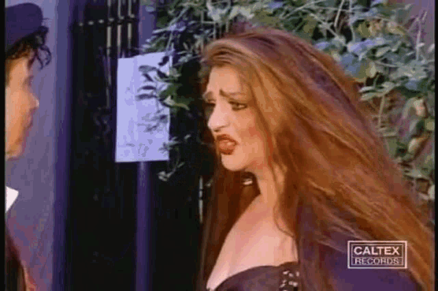 a woman with long red hair is standing next to a man in a caltex records ad .