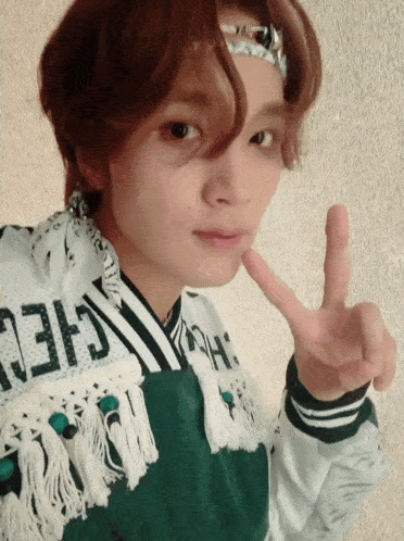a person wearing a green and white sweater with the word cheer on it