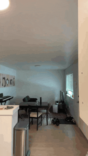 a dining room with a table and chairs and a trash can