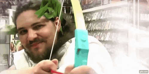 a man with a beard is holding a bow and arrow in his hands .