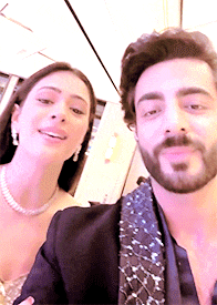 a man and a woman are posing for a selfie together