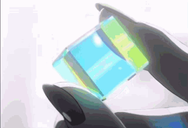 a person is holding a blue and yellow cube in their hand .