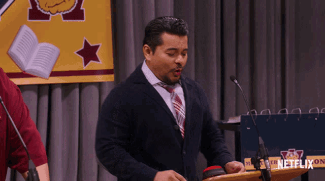 a man stands behind a podium with a netflix logo on it