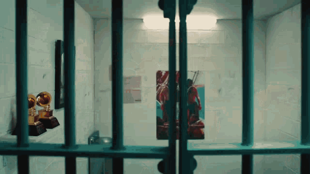 a jail cell with a painting on the wall and a trophy on the shelf
