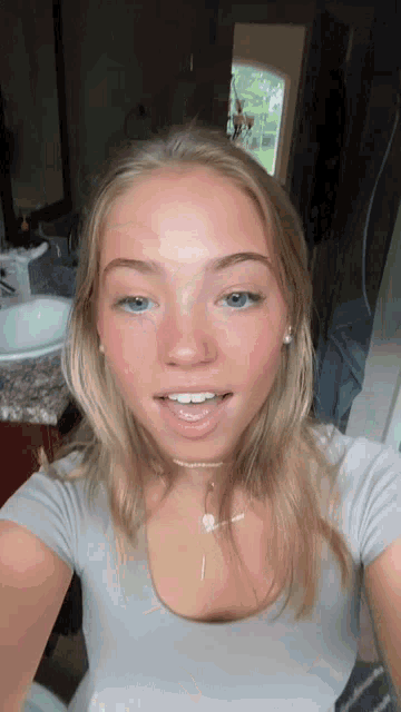 a woman taking a selfie with her mouth open