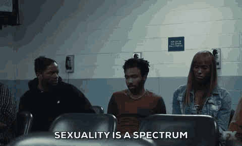 a group of people are sitting in a waiting room and the words sexuality is a spectrum are visible .