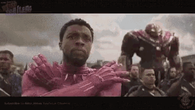 a man in a pink iron man suit is standing in front of a crowd .