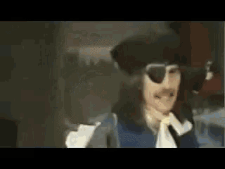 a man is wearing a pirate hat and sunglasses .
