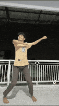 a man is dancing on a balcony with his arms outstretched