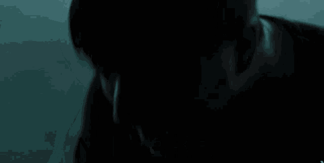 a man in a dark room with the words " and i will be " above him