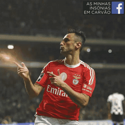 a soccer player wearing a red emirates jersey celebrates a goal