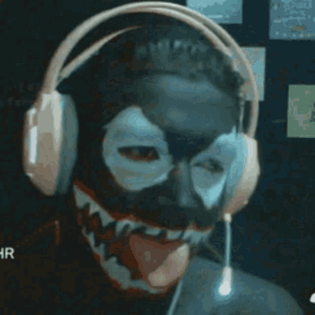 a man wearing headphones and a mask with his tongue hanging out