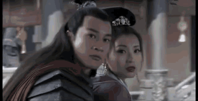 a man and woman are standing next to each other in a room .