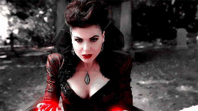 a woman in a black and red dress is holding a red object