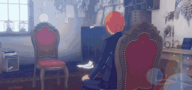 a man with red hair is sitting in a chair