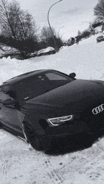 a black audi is parked in a snowy area
