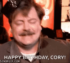 a man with a mustache and a crown on his head is saying happy birthday cory .