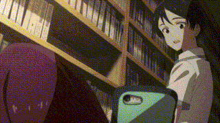 a man is standing in front of a bookshelf holding a cell phone .