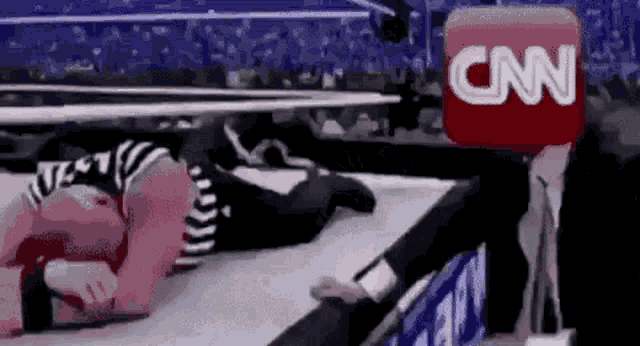 a cartoon of a wrestling match with a cnn logo in the foreground