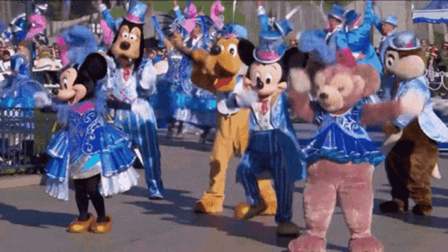 a group of mickey mouse and friends are dancing together