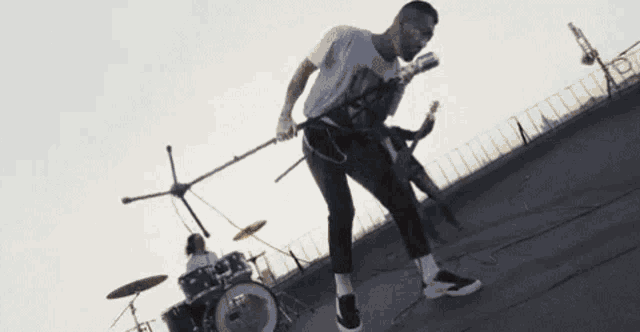 a man is playing a guitar and singing into a microphone .