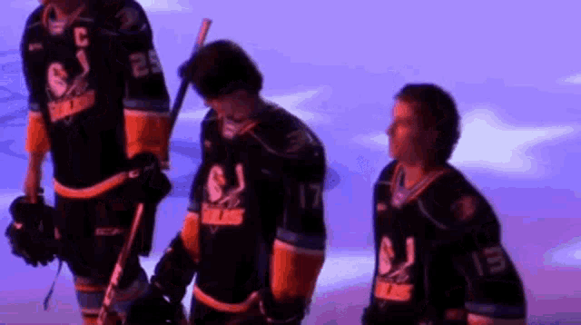 a group of hockey players are standing on the ice and one of them has the number 17 on his jersey