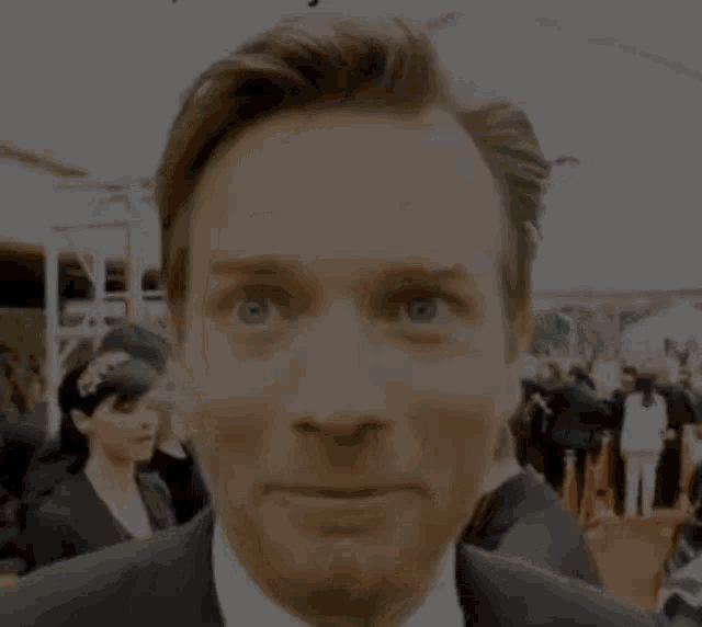 a man in a suit and tie making a face