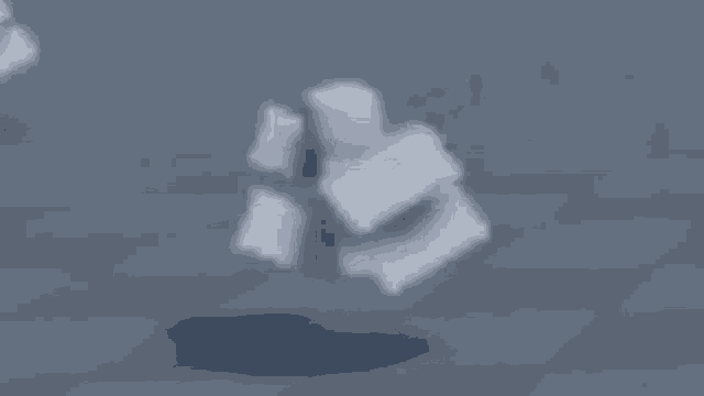 a white roblox character is walking across a gray surface .