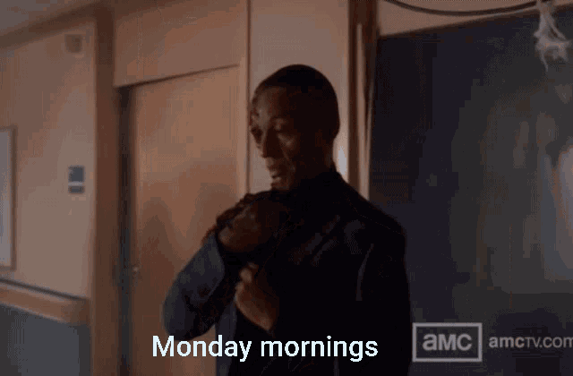 a man in a suit is standing in a hallway and says monday mornings