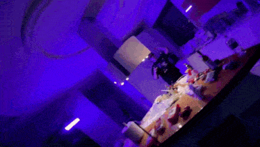 a man is standing in a kitchen with purple lights and a bowl of cereal on the counter .