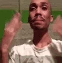 a bald man with a beard is wearing a white shirt and making a funny face .