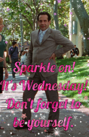 a man in a suit stands in front of a sign that says sparkle on wednesday do n't forget to be yourself