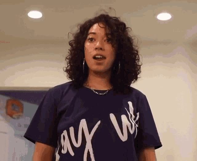 a woman wearing a purple t-shirt that says say we