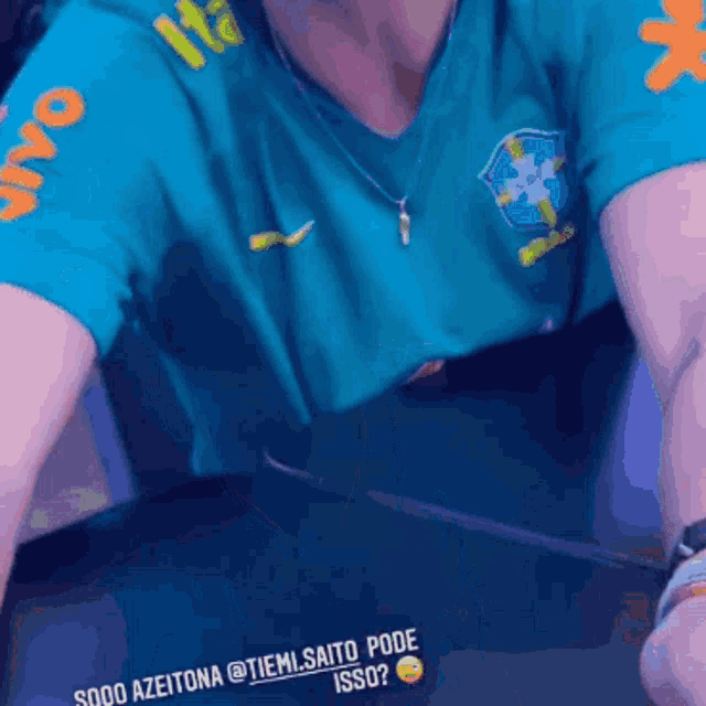 a person wearing a blue shirt with the word ita on the sleeves