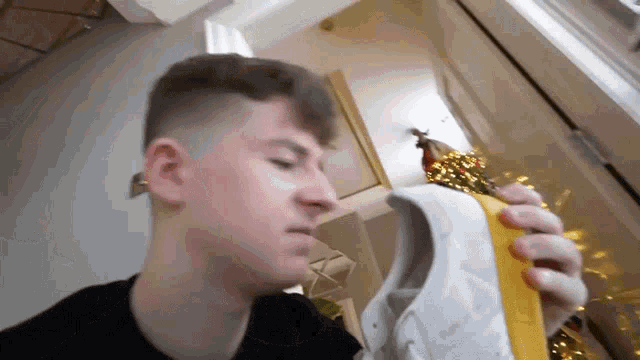 a young man smells a pair of white shoes