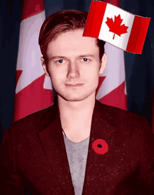a man with a red jacket and a poppy pin has a canadian flag on his head