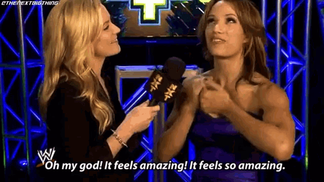 two women are talking into microphones and one of them is saying oh my god it feels amazing it feels so amazing