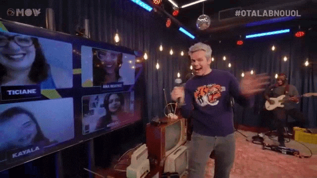 a man singing into a microphone in front of a screen that says ana beatrice on it