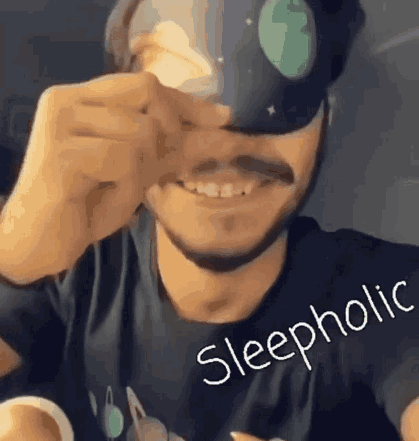 a man wearing a sleep mask with the word sleepholic written on it