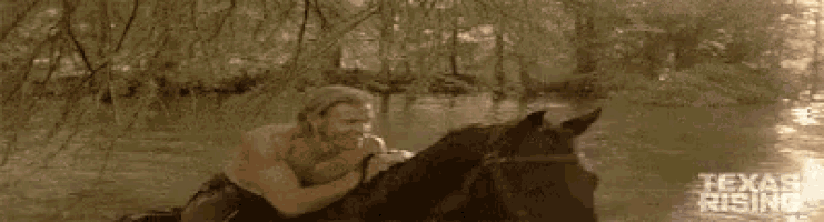 a man is kneeling on a horse in the water .