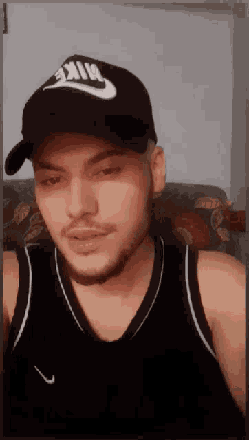 a man wearing a nike hat and a nike tank top
