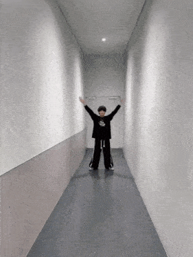 a person standing in a hallway with their arms up