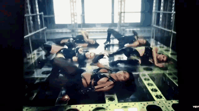 a group of women are laying on top of each other on a stage .