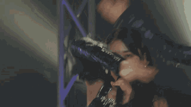 a woman singing into a microphone while another woman applauds