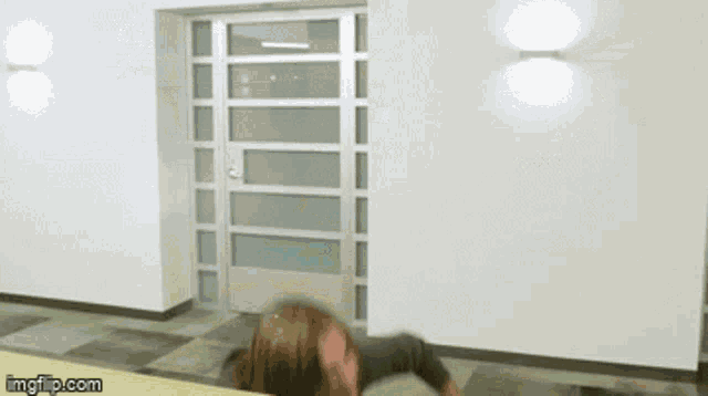 a man with long hair is standing in front of a door with imgflip.com at the bottom of the screen